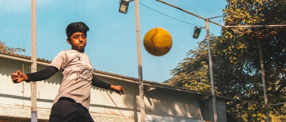 man in gray shirt playing basketball during daytime