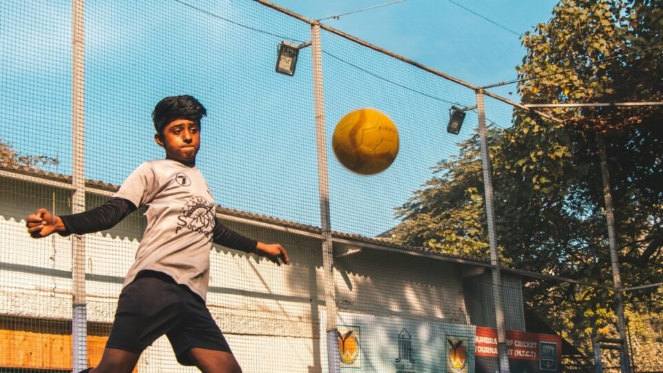 man in gray shirt playing basketball during daytime